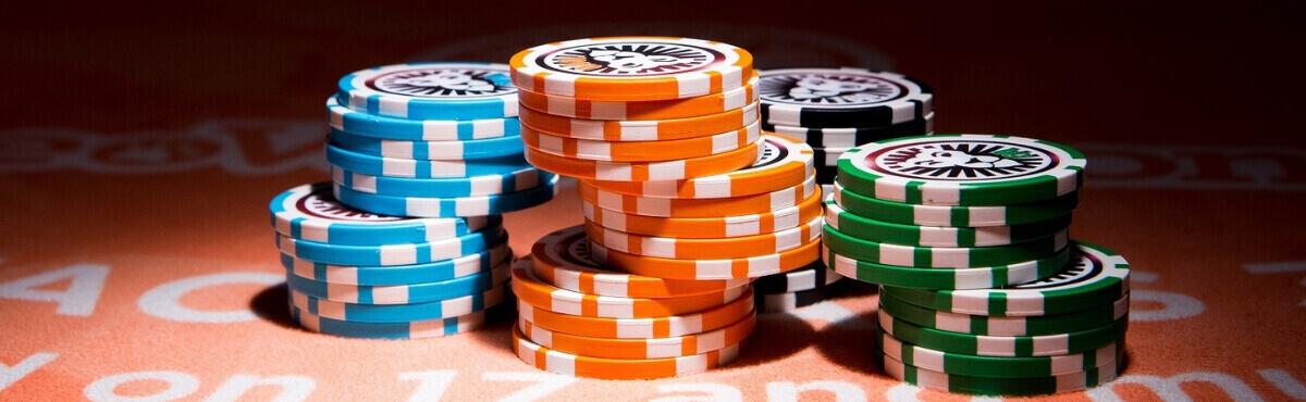 Roulette-Chips auf einem orangefarbenen Spieltisch.